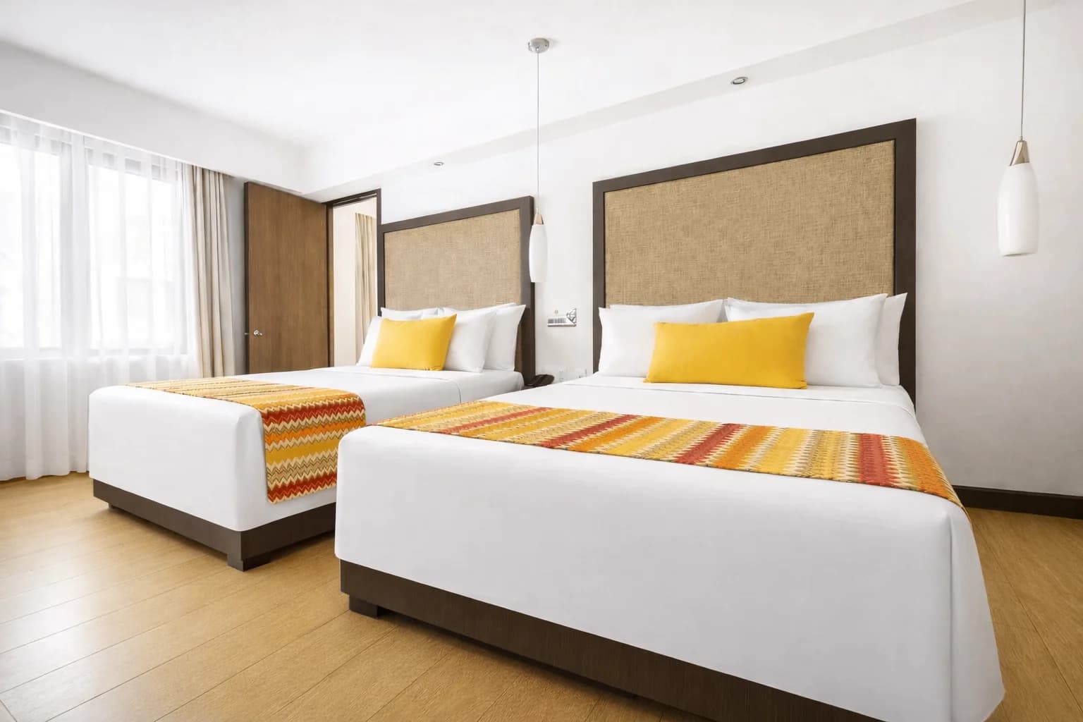 Hotel Catedral 패밀리룸. 더블 침대 2개, 따뜻한 색감, 나무 바닥.